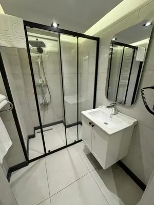 a white bathroom with a shower and a sink at Mateo in Istanbul
