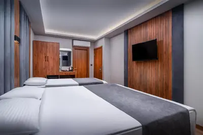 a bedroom with a white bed and a flat screen tv at Elite Port Hotel Istanbul Airport in Arnavutköy