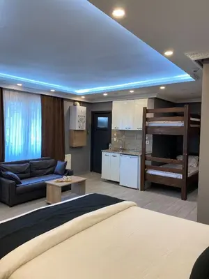a bedroom with a bed and a couch and a kitchen at Sahra Kent Otel Kadıköy in Istanbul