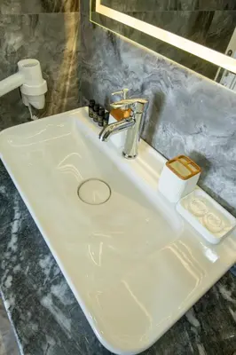 a white bathroom sink with aaucet and a soap dispenser at Linda Port Hotel in Istanbul
