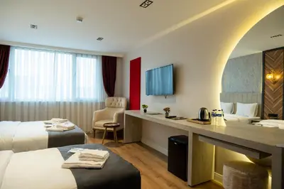 a hotel room with two beds and a desk at Linda Port Hotel in Istanbul