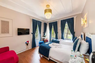 a bedroom with two beds and a red couch at Begonville Corner in Istanbul