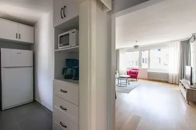 a kitchen with a white refrigerator and a living room at 2BR Bright Kadıköy Apartment & AC in Every Room in Istanbul
