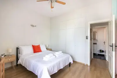 a white bedroom with a large white bed with red pillows at 2BR Bright Kadıköy Apartment & AC in Every Room in Istanbul