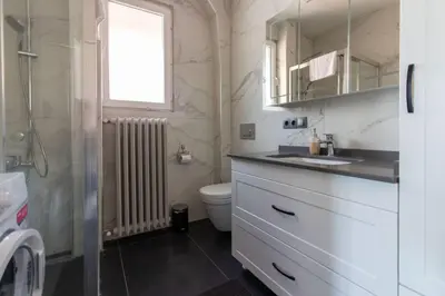 a bathroom with a sink and a toilet and a window at 2BR Bright Kadıköy Apartment & AC in Every Room in Istanbul
