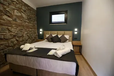 a bedroom with a large bed with a stone wall at Mia Mia Suites in Istanbul