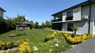 a yard with yellow flowers next to a building at Sapanca Villa Dereiçi in Sapanca