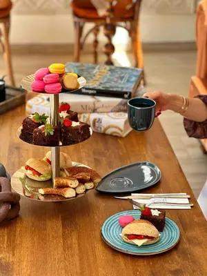 a woman reaching for a cup of coffee on a table with food at Blu Macel Hotel & Suites -Old City Sultanahmet in Istanbul