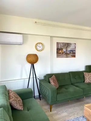 a living room with two green couches and a clock at King Suite SA2 in Esenyurt