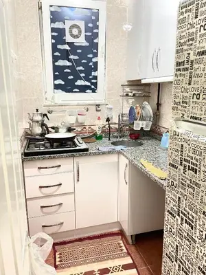 a kitchen with white cabinets and a sink and a window at Best house for family in Istanbul