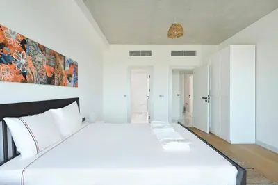 a white bedroom with a large white bed at Cool Airy Modern 2bd2bath Parkingpoolgym! #219 in Istanbul