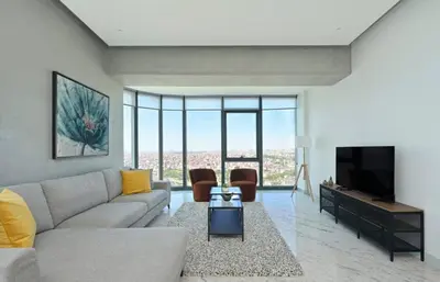 a living room with a couch and a tv at Cool Airy Modern 2bd2bath Parkingpoolgym! #219 in Istanbul