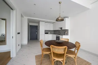 a kitchen and dining room with a wooden table and chairs at Lovely Modern 1BD Condo Views w PoolGym! #222 in Istanbul