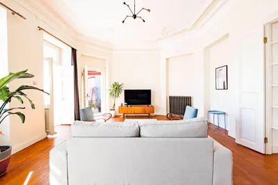 a living room with a white couch and a tv at Homie Suites - Turna Residences in Cihangir in Istanbul