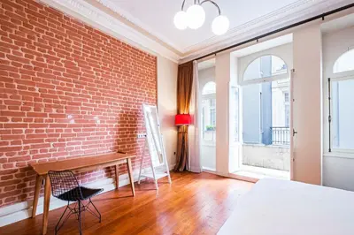 a room with a brick wall and a table and chair at Homie Suites - Turna Residences in Cihangir in Istanbul