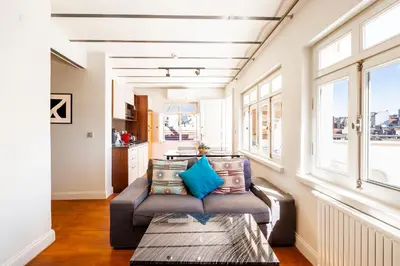 a living room with a couch and windows at Homie Suites - Turna Residences in Cihangir in Istanbul