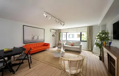 a living room with an orange couch and a table at Modern Prime Location 2BD1Bath Cozy Home! #213 in Istanbul