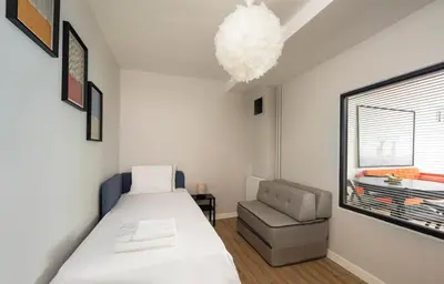a bedroom with a bed and a chair and a window at Modern Prime Location 2BD1Bath Cozy Home! #213 in Istanbul