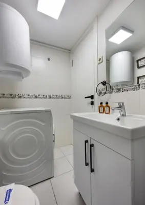 a white bathroom with a sink and a toilet at Modern Prime Location 2BD1Bath Cozy Home! #213 in Istanbul