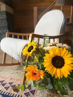 a bouquet of sunflowers in front of a chair at MİNNA BUTİK EV in Sapanca