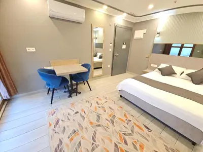 a bedroom with a bed and a desk and a table at Sahrakent Otel Pendik in Istanbul