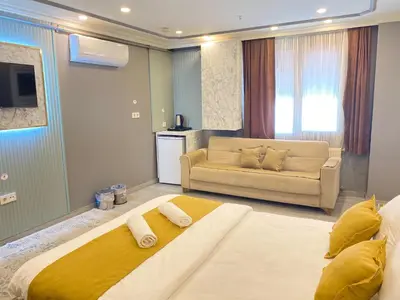a large bedroom with a large bed and a couch at Sahrakent Otel Pendik in Istanbul