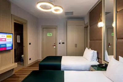 a hotel room with two beds and a flat screen tv at THE NEST HOTEL in Istanbul