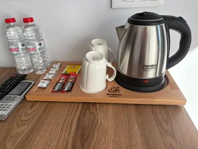a coffee maker on a wooden tray with water bottles at Business Life Hotel Güneşli in Istanbul