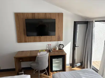 a bedroom with a desk and a television on a wall at Business Life Hotel Güneşli in Istanbul