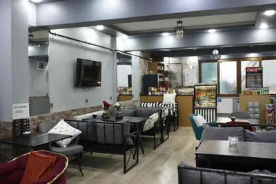 a restaurant with tables and chairs and a tv at Birlik Apart Hotel in Istanbul