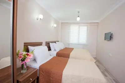a bedroom with two beds and a vase of flowers at Birlik Apart Hotel in Istanbul
