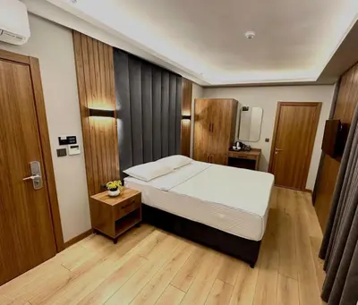 a bedroom with a large bed and a wooden floor at Hotel And free shuttle in Istanbul