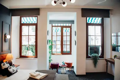 a living room with windows and a table and chairs at Istiklal Street Taksim House Yamalya Hotel in Istanbul