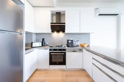 a kitchen with white cabinets and stainless steel appliances at Homie Suites - Luxury Apartments in Maçka in Istanbul