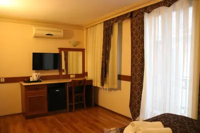 a hotel room with a bed and a desk with a television at Grand Peninsula Hotel in Istanbul