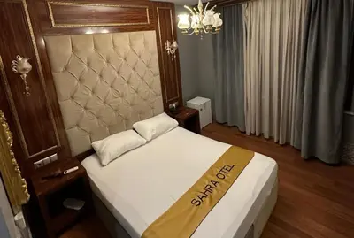 a bedroom with a bed with a large headboard at Sahra Airport Hotel in Istanbul