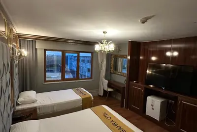 a hotel room with two beds and a flat screen tv at Sahra Airport Hotel in Istanbul