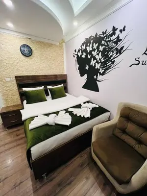 a bedroom with two beds and a chair at Bona apart in Istanbul