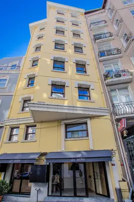 a tall yellow building with windows on a street at Joy Taksim in Istanbul