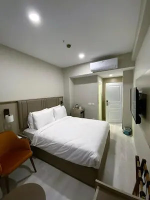 a bedroom with a large white bed and a chair at Joy Taksim in Istanbul