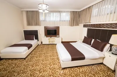 a hotel room with two beds and a television at Şişli Luxury K Suites Hotel in Istanbul