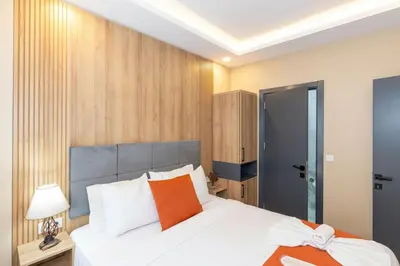 a bedroom with a large white bed with an orange pillow at hotel La Vitrine in Istanbul