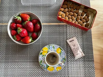 a table with a bowl of strawberries and a cup of coffee at Myfair apartment in Istanbul