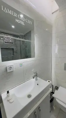 a bathroom with a sink and a mirror and a toilet at La Mer Old City Hotel in Istanbul