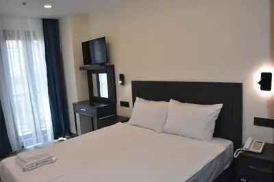 a bedroom with a bed with a television on the wall at Shishly Palace Hotel in Istanbul