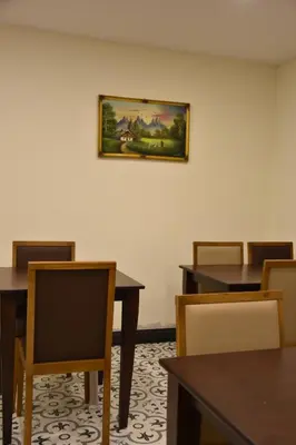 a room with tables and chairs and a painting on the wall at Shishly Palace Hotel in Istanbul