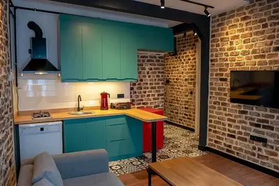 a kitchen with green cabinets and a couch in a room at Alness Residence in Istanbul