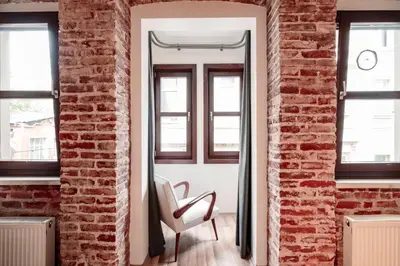 a brick room with a chair and a mirror at Homie Suites - Modern Apartments Nearby Istıklal Street & Galata Tower in Istanbul