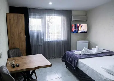 a bedroom with a bed and a table and a window at İdeal Butik Otel in Arnavutköy