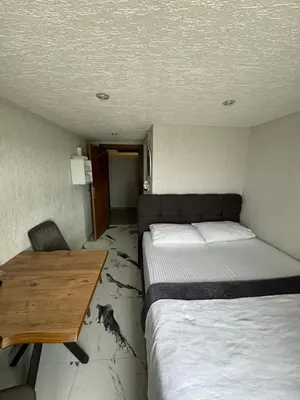 a room with two beds and a desk and a table at İdeal Butik Otel in Arnavutköy
